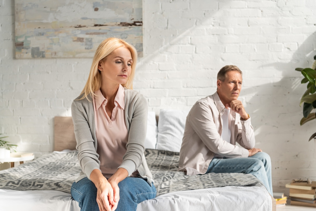 Worried couple on bed.