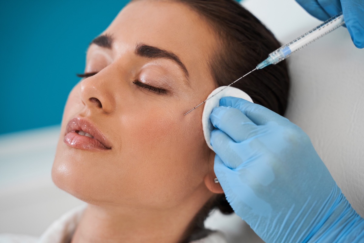 A woman receiving cheek filler injections
