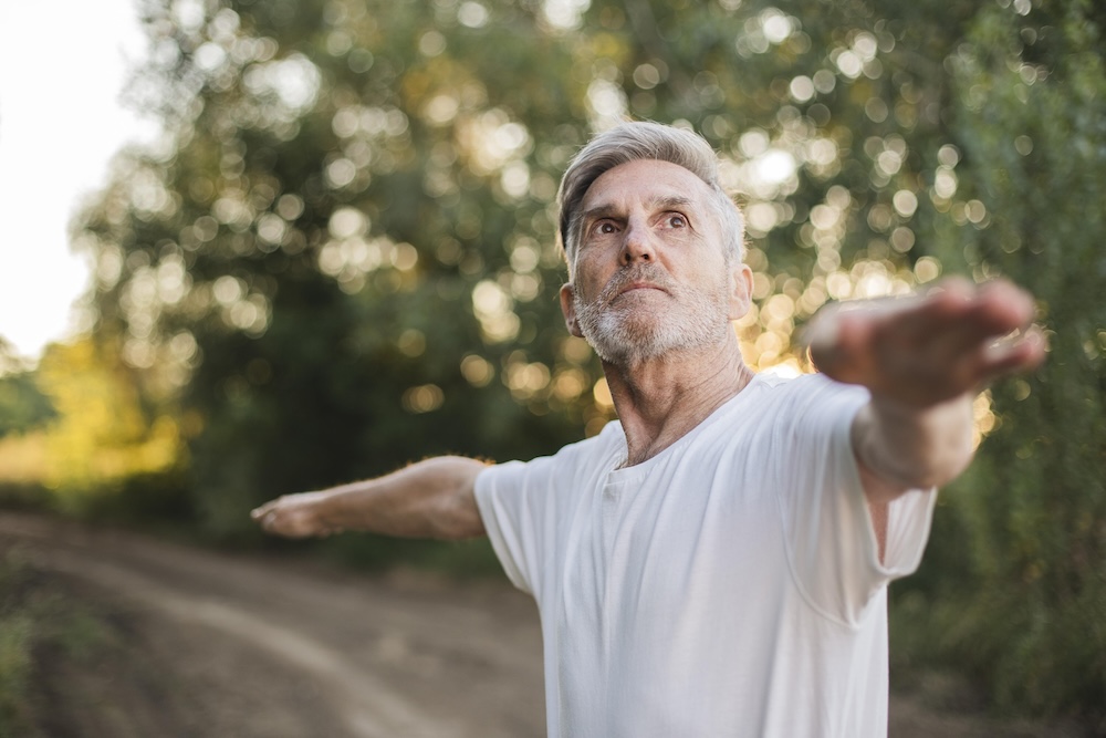 A man in doing yoga with outstetched arms